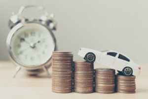 White miniature car on money coin stack growth with clock