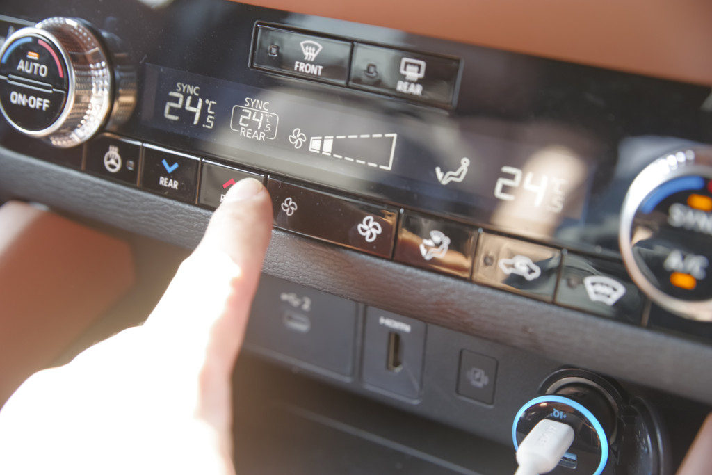 カーエアコンの温度調整をする男性